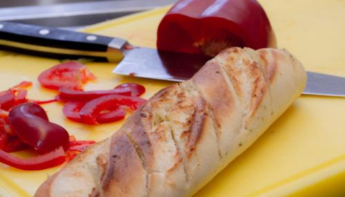 a piece of food on a cutting board with red peppers at Hotel Alpenblick in Bach