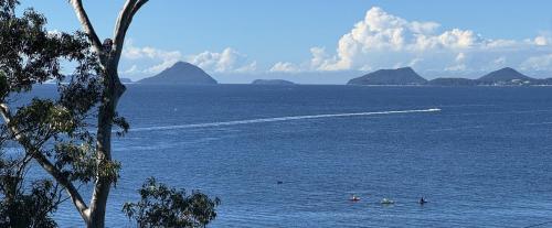 a group of people in the water with a boat at Tranquil Escape - Koala Hotspot - 2 Bed 2 Bath Apt Spectacular Sea Views in Soldiers Point