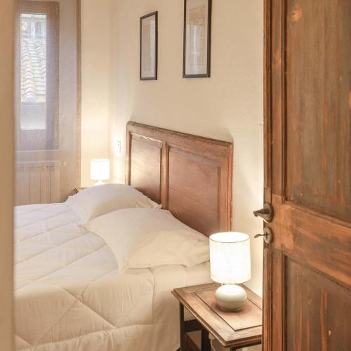 a bedroom with a bed and a table with a lamp at Holiday Home Adelaide in Pienza