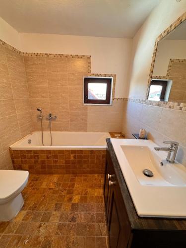 a bathroom with a tub and a sink and a toilet at Voila House in Voila