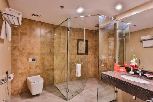 a bathroom with a shower and a toilet and a sink at Avari Xpress Multan in Multan