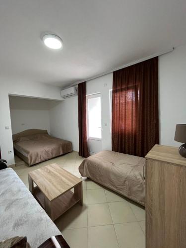 a hotel room with two beds and a window at belaapartmani in Bar