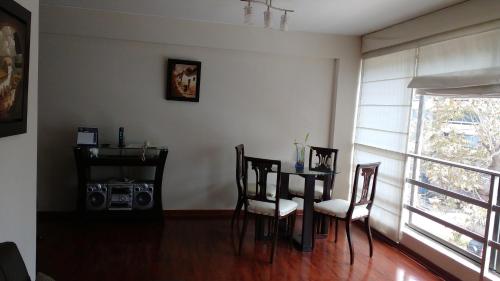 comedor con mesa, sillas y radio en Apartamentos Amoblados de 1 Y 2 dormitorios, en Lima