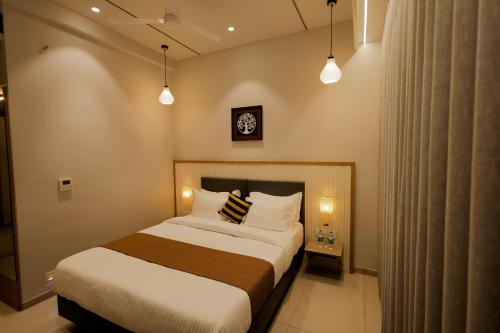 a bedroom with a bed and a clock on the wall at Balaji Hotel in Somnath