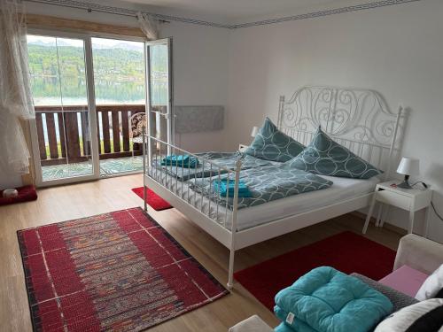 a bedroom with a bed and a balcony at Haus Seeblick in Töschling