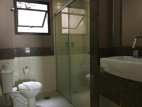a bathroom with a toilet and a sink and a shower at Hotel Lugus in Sao Paulo