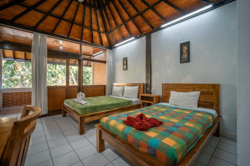 a bedroom with two beds in a room at Argasoka Bungalows in Ubud