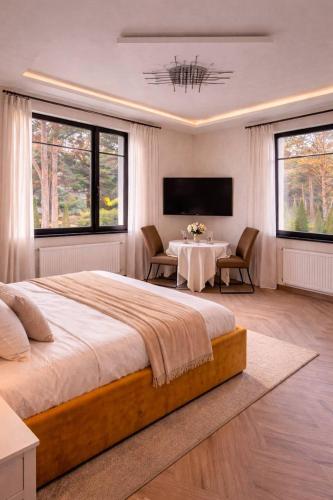 a bedroom with a large bed and a table with chairs at GRAND APARTMENT BALTEZERS in Riga