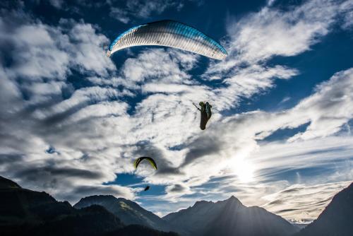 two paragliders are flying in the sky at Hotel Alpenblick in Bach