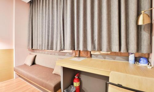 ein Zimmer mit Schreibtisch, Tisch und Fenster in der Unterkunft Bay Hound Hotel in Busan