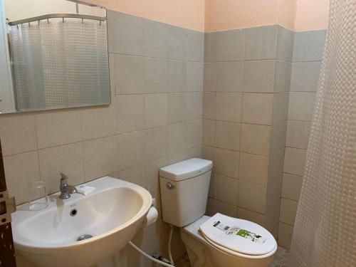 ein Badezimmer mit Toilette und Waschbecken in der Unterkunft โรงแรมพิณ in Lampang