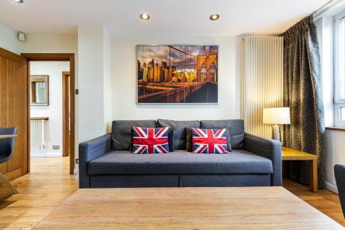 a living room with a blue couch with british cushions at Tower Bridge 2BR apartment for 6 with terrace in London