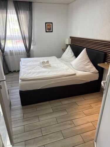 a bedroom with a large bed with white sheets at Hotel Rhein INN in Remagen