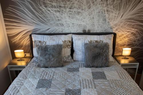 a bedroom with a bed with pillows and two lamps at Apartment Mama Lisa in Lauterach