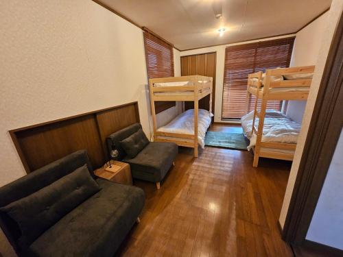 a living room with two bunk beds and a couch at BASE CAMP Kitakaruizawa in Naganohara