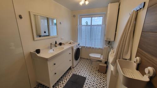 a bathroom with a sink and a toilet and a mirror at Kose apartment in Kose