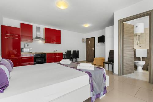 a bedroom with a large white bed and red cabinets at LotusPoolApart in Premantura