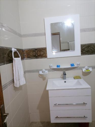 a bathroom with a sink and a mirror at Beach lodge in Chebba