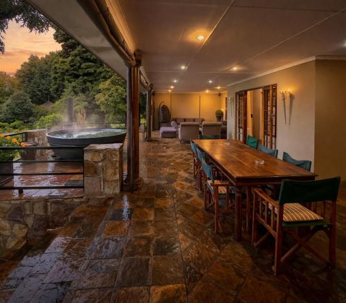 a large patio with a wooden table and a tub at Luxury Country Retreat Hot Tub & Farm Views in Dullstroom