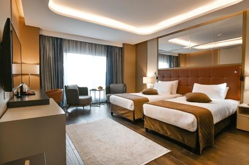 a hotel room with two beds and a mirror at Petra Moon Luxury Hotel in Wadi Musa