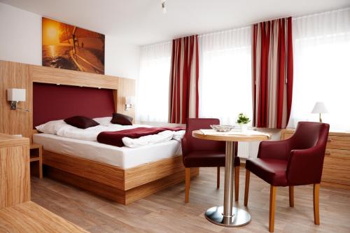 a hotel room with a bed and a table and chairs at Schlicks Dümmer Kojen in Lembruch