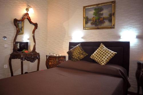 a bedroom with a bed and a mirror on the wall at Hotel Anesi in Athens