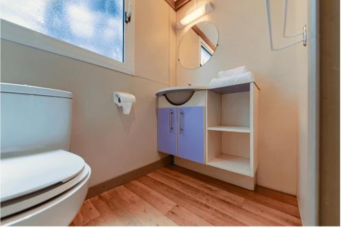 a bathroom with a toilet and a sink and a mirror at Kampaoh Conil in Conil de la Frontera