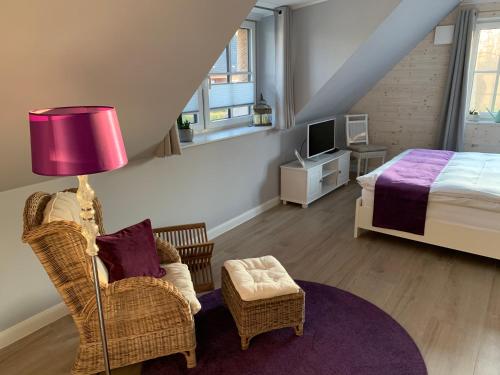 a bedroom with a bed and a chair and a lamp at Reetdachhaus Seestern in Garding