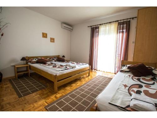 1 dormitorio con 2 camas y ventana grande en Apartments Trošelj en Starigrad-Paklenica
