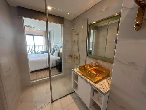 a bathroom with a shower and a sink and a mirror at Luxury Studio Infinity Pool Golden Bay in Danang