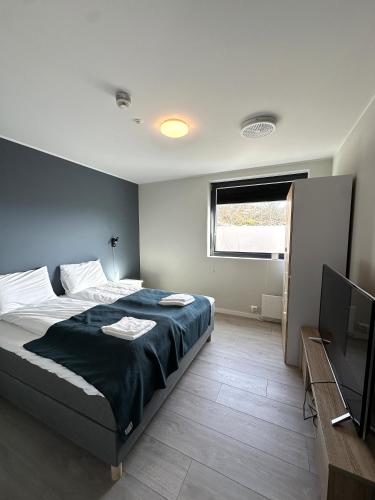 a bedroom with a bed and a flat screen tv at Torghatten Lodge in Torget