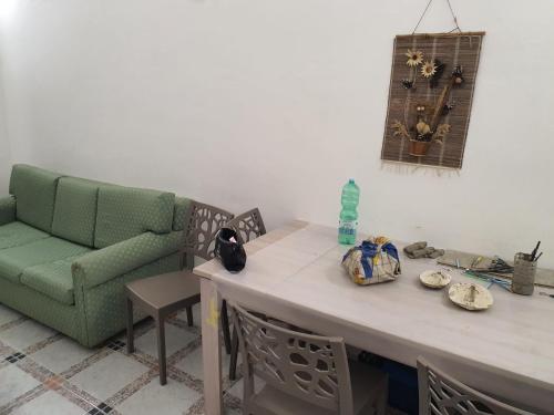 a living room with a table and a green couch at Residenza Delizia in Gallipoli