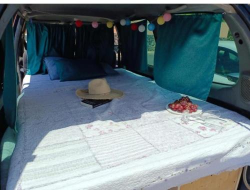 a bed in the back of a van with a hat at Tenerife Camper Van Teide Surf and Beaches Sleeps 2 in San Miguel de Abona