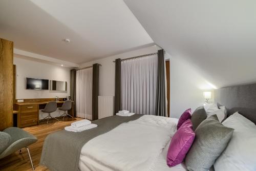 a hotel room with a large bed with purple pillows at Hotel Górski in Białka Tatrzanska