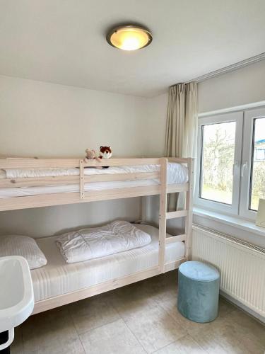 a bedroom with two bunk beds and a window at De Snip in Ballum