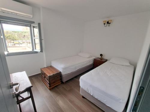 a bedroom with two beds and a window at Olive Mill Complex in Livadi