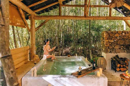 a woman sitting in a hot tub in a house at Congxi Creek Resort in Conghua