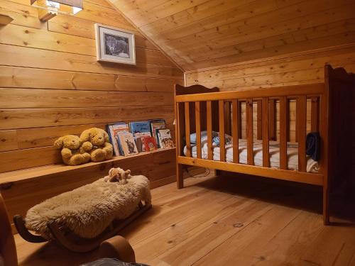 a room with a crib in a log cabin at Chalet Les Vosgiennes in Le Valtin