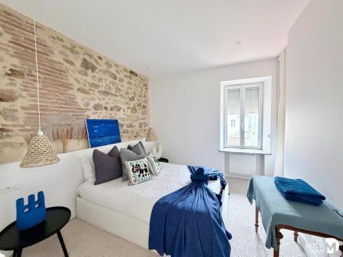 a bedroom with a white couch and a brick wall at Maison du Caboteur de La Baule, Centre & plage à pied, Patio cosy, 8 pers in Le Pouliguen