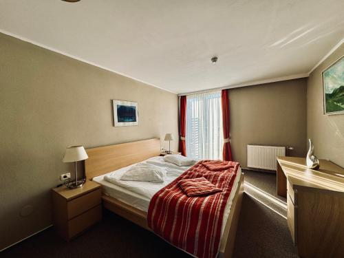 a hotel room with a bed and a window at Hotel Atrium in Târgu Secuiesc