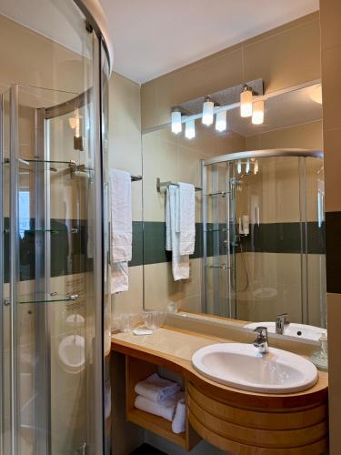 a bathroom with a sink and a shower at Hotel Atrium in Târgu Secuiesc