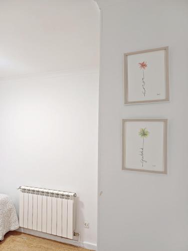 a bedroom with two pictures of a palm tree on the wall at La Dama Boba in Olmedo