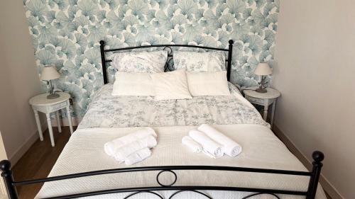 a bedroom with a bed with towels on it at La Maison du Rosier in Saint-Honoré-les-Bains