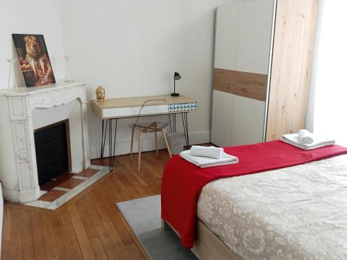 a bedroom with a desk and a bed with a red blanket at Appartement de cachet de 63m2 in Moulins