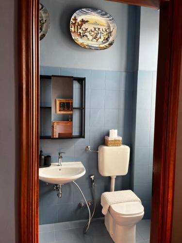 a bathroom with a white toilet and a sink at Locanda Orticello in Monferrato in Cremolino