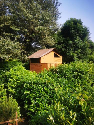 a small building sitting in the middle of a field of bushes at Camping le Terriol - Onlycamp in Cajarc