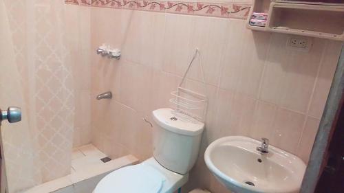 a bathroom with a toilet and a sink at Casa vacanza, Mendosa in Bayaguana