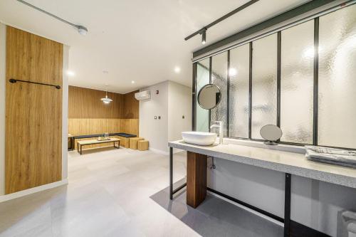 a bathroom with a sink and a mirror at Restia Hotel Suwon Station in Suwon