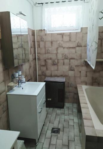 a bathroom with a sink and a bath tub at Györkös Apartman in Balatonszárszó