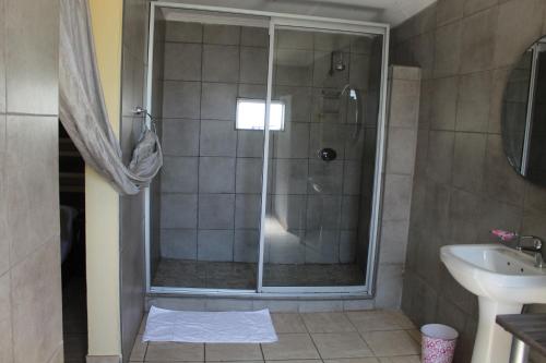 a bathroom with a shower and a sink at Ruacana Guest House in Ruacana